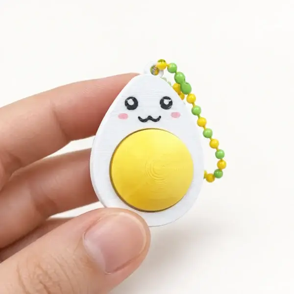 Smiley Egg Clickers, Classic yolk - open eyes, a small printed item in the pictured colors