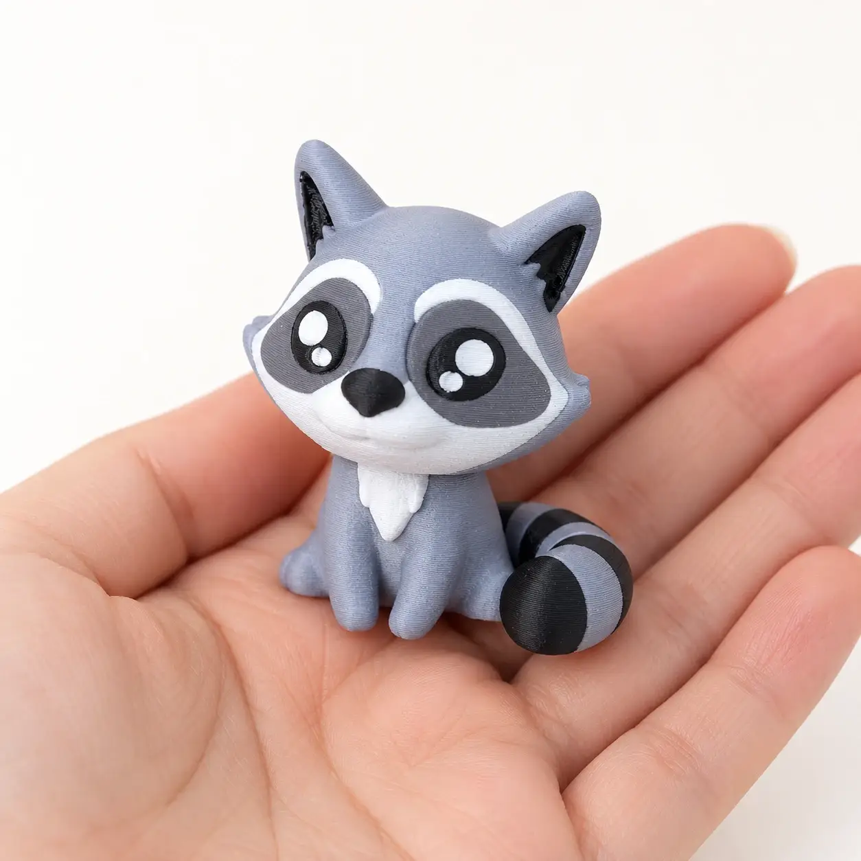 Raccoon Clicker, Seated raccoon, a small printed item in the pictured colors