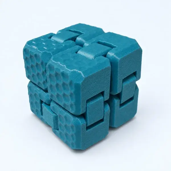 Teal folding fidget cube with honeycomb texture, shown closed